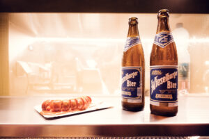 Classic Viennese pairing of beer and sausage at Bitzinger Würstelstand, a must-try local delight.