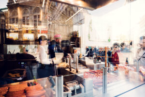 Skilled preparation of sausages at Bitzinger Würstelstand, showcasing the art of Viennese street cuisine.