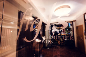 Glass door entrance of Figls restaurant in Vienna.