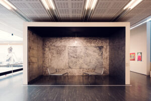 The exhibition space at Belvedere 21 includes a unique installation featuring a small, enclosed area with dark, textured walls.