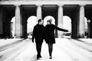 Adriana and Mario at snow-covered main gate of Heldenplatz, creating a magical winter scene.