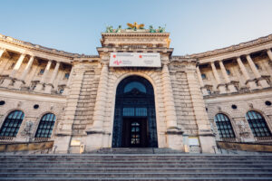 Elegant entrance of the Austrian National Library at Heldenplatz, inviting visitors inside.