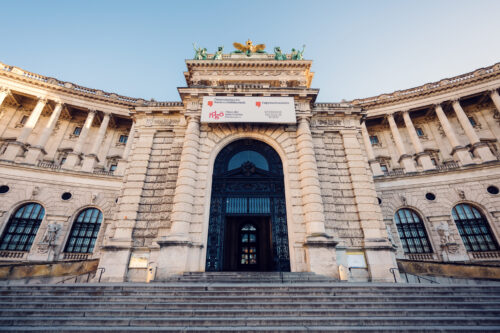 Elegant entrance of the Austrian National Library at Heldenplatz, inviting visitors inside.
