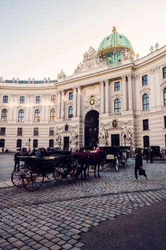 Picturesque view of a fiaker in front of Hofburg Palace, blending history and tradition.