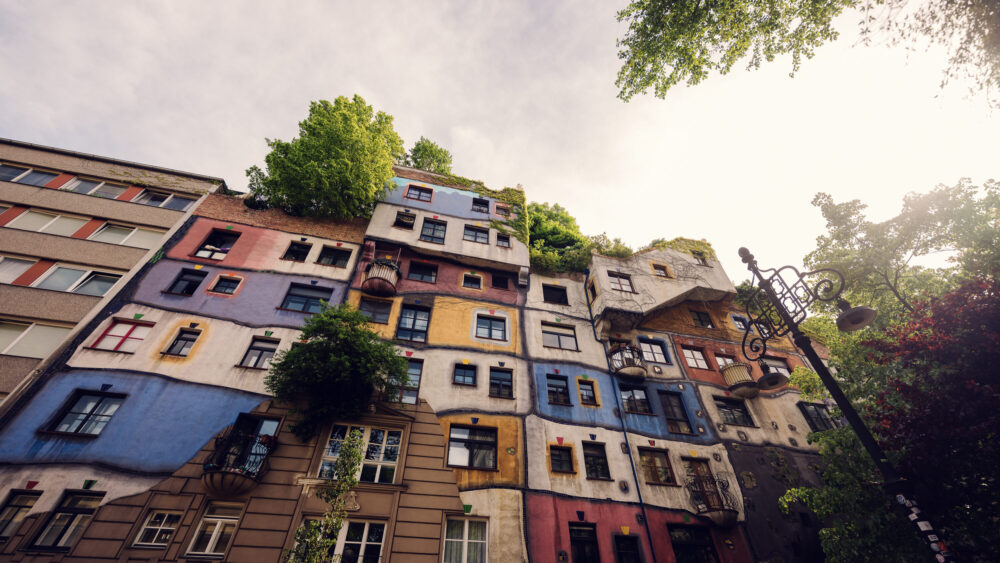 Whimsical windows of Hundertwasserhaus, each uniquely shaped and decorated, telling stories of Friedensreich Hundertwasser's artistic vision.