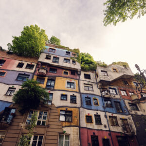 Finestre colorate della Hundertwasserhaus, ognuna con forma e cornice diverse.