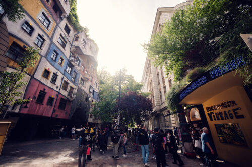 Iconic Hundertwasserhaus facade at sunrise, where undulating lines and vibrant mosaics create a fairytale scene.