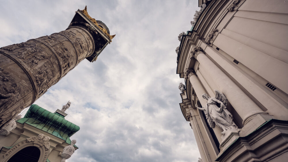 One of the ornate columns and the exterior facade of St. Charles Church (Karlskirche) in Vienna