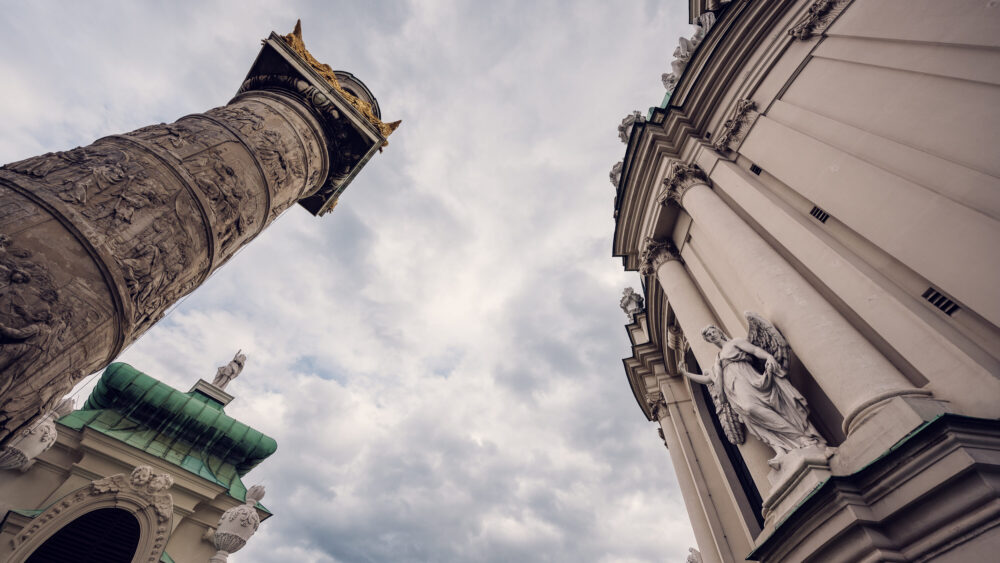 One of the ornate columns and the exterior facade of St. Charles Church (Karlskirche) in Vienna.