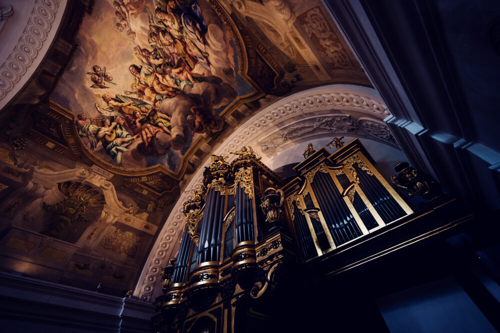 The grand organ inside St. Charles Church (Karlskirche), with its ornate golden pipes standing beneath a stunning baroque fresco