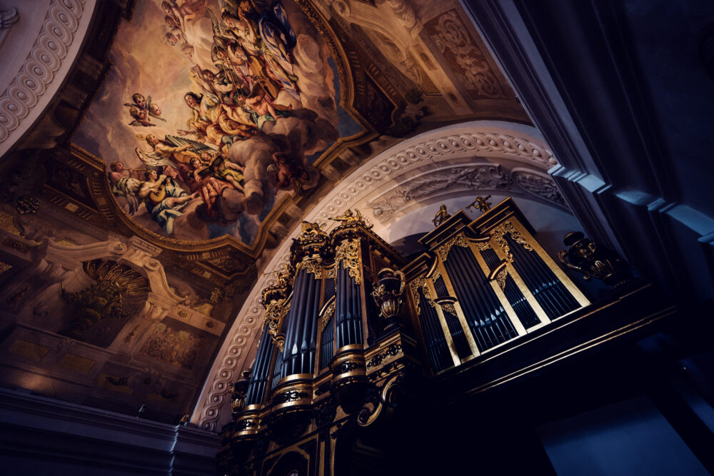 The grand organ inside St. Charles Church (Karlskirche), with its ornate golden pipes standing beneath a stunning baroque fresco.