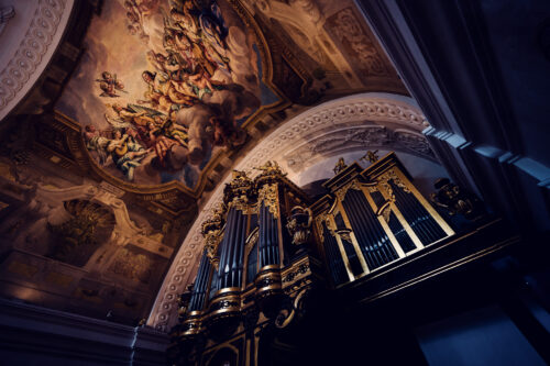 The grand organ inside St. Charles Church (Karlskirche), with its ornate golden pipes standing beneath a stunning baroque fresco.