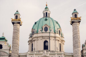 A close-up of St. Charles Church (Karlskirche) green dome and twin intricately carved columns