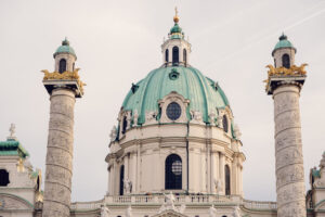 A close-up of St. Charles Church (Karlskirche) green dome and twin intricately carved columns.