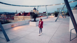 Adriana posing at MQ Libelle Vienna with modern glass architecture and beautiful museum quarter backdrop.