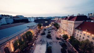Cultural crossroads at MuseumsQuartier's central plaza featuring diverse architectural styles.
