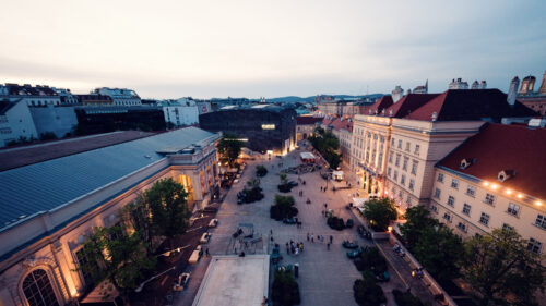 Cultural crossroads at MuseumsQuartier's central plaza featuring diverse architectural styles.