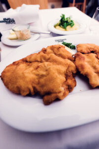 Traditional Wiener Schnitzel service at Plachutta zur Oper, where centuries of culinary expertise meet premium ingredients.