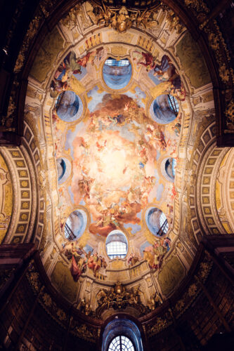 Ceiling frescoes of the Prunksaal, where mythological figures dance across a canvas of gold and pastels.
