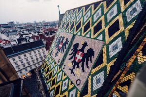 Iconic mosaic roof of St. Stephen's Cathedral, its 230,000 glazed tiles creating the distinctive double-headed eagle and Vienna's coat of arms.