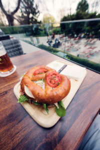 Traditional Viennese pretzel (Brezel) served on rustic wooden board at Stöckl im Park restaurant.