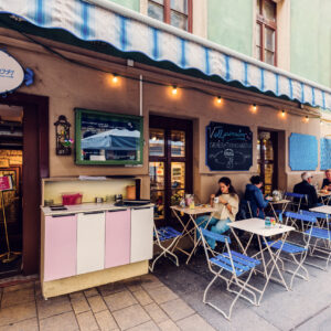 The exterior of Vollpension, featuring a colorful and inviting outdoor seating area.