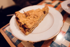 A slice of Vollpension's classic Grandma’s apple cake, served on a vintage white plate.