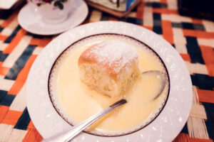 Vollpension's famous Buchtel, a soft, fluffy Austrian sweet roll, served in a generous pool of warm vanilla sauce.
