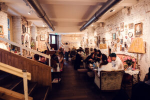 The cozy interior of Vollpension, with guests seated at various tables enjoying their food and drinks