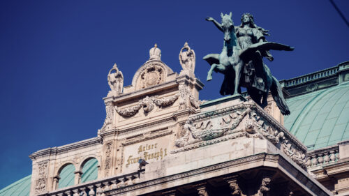 Ornate rooftop details of the Vienna State Opera.
