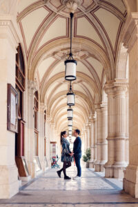 Portrait of Adriana and Mario at the majestic columns of the Vienna State Opera, capturing timeless elegance.