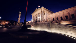 Austrian Parliament illuminated at night, showcasing its architectural beauty.