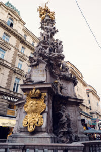 The coats of arms on the Pestsäule represent the Habsburg Monarchy and emphasize the emperor’s role as a ruler chosen by God.
