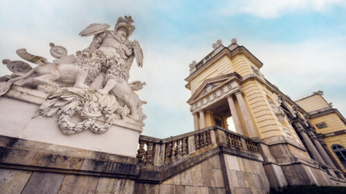 Elegant stone sculptures flanking the grand staircase of the Gloriette.
