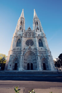 Main entrance portal of Votivkirche Vienna with detailed stone sculptures and Gothic arches.