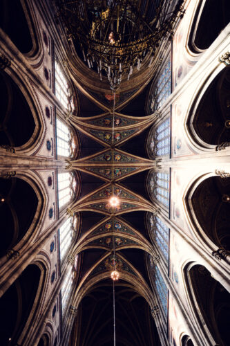 Soaring ribbed vaulting of Votivkirche Vienna (Votive Church) reaching 30 meters high with intricate neo-Gothic stone tracery, intersecting arches, and structural supports.