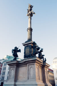 The Marian Column am Hof, Vienna, is a prominent monument featuring a statue of the Virgin Mary, surrounded by elegant Baroque architectural elements, symbolizing protection and grace.