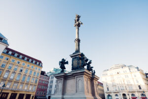 The Marian Column am Hof, Vienna, is a prominent monument featuring a statue of the Virgin Mary, surrounded by elegant Baroque architectural elements, symbolizing protection and grace.