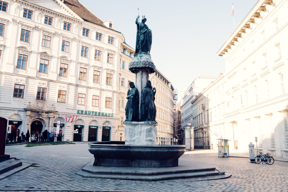 The Austriabrunnen at Freyung Square, Vienna, a beautiful fountain surrounded by historic architecture and vibrant city life.
