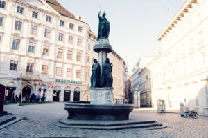 The Austriabrunnen at Freyung Square, Vienna, a beautiful fountain surrounded by historic architecture and vibrant city life.