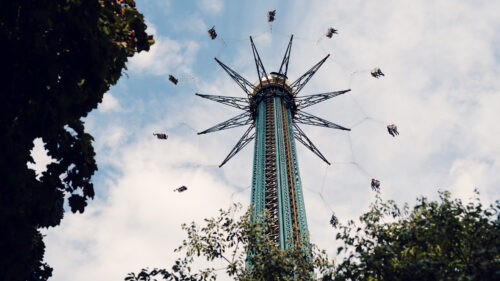Prater Tower carousel Vienna Austria, tall rotating amusement ride with elevated gondolas offering scenic views over Vienna cityscape in traditional Wiener Prater district.
