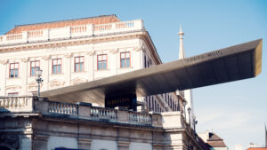 Modern architectural extension of Albertina Museum seen against the sky.