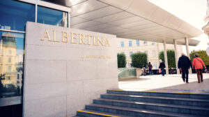 Entrance of Albertina Museum with modern architectural elements and visitors.