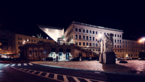 Albertina Museum illuminated at night with a view of nearby buildings.