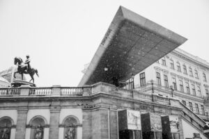 Historical equestrian statue near the modern roof extension of Albertina Museum.