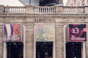 Front facade of Albertina Museum featuring art exhibition banners in Vienna.