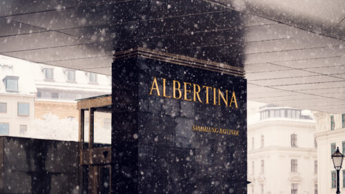 Albertina Museum sign with snow-covered exterior and historical backdrop.