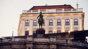 Evening view of Albertina Square with the statue of Archduke Albrecht and illuminated buildings.