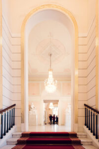 Ornate staircase in Albertina Museum with marble steps and detailed architecture.