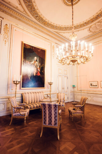 Lavish salon in Albertina Museum featuring a chandelier and period furniture.